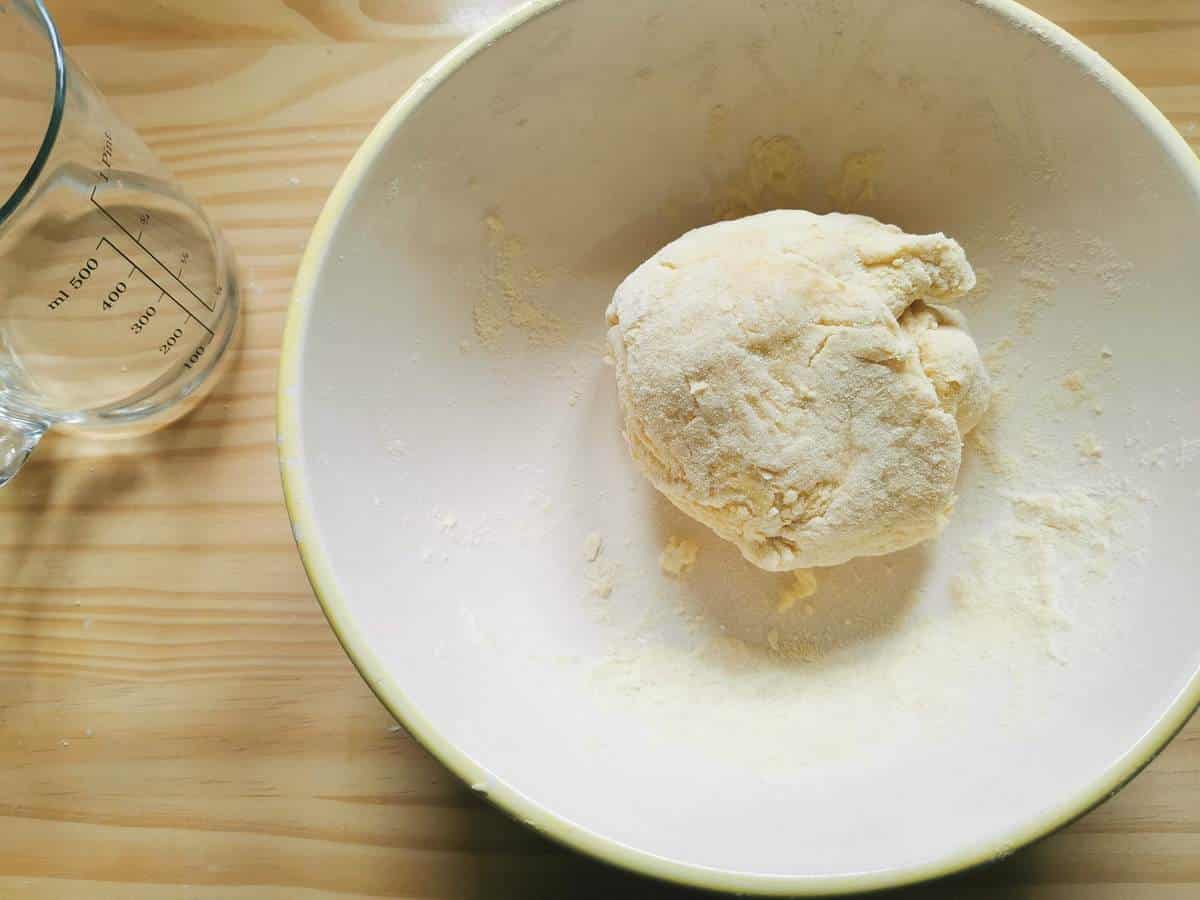 Ball of casoncelli dough in white bowl.