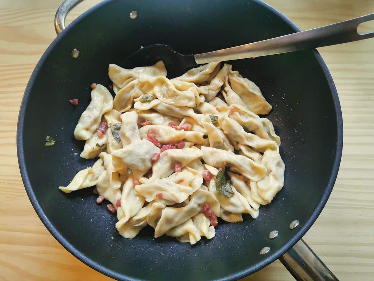 Casoncelli (casoncsei) in large pan with butter, sage and pancetta.