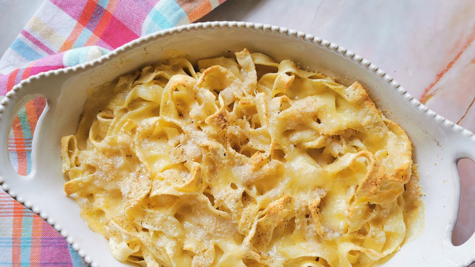 Ready to serve baked tagliatelle in a white oval oven dish.