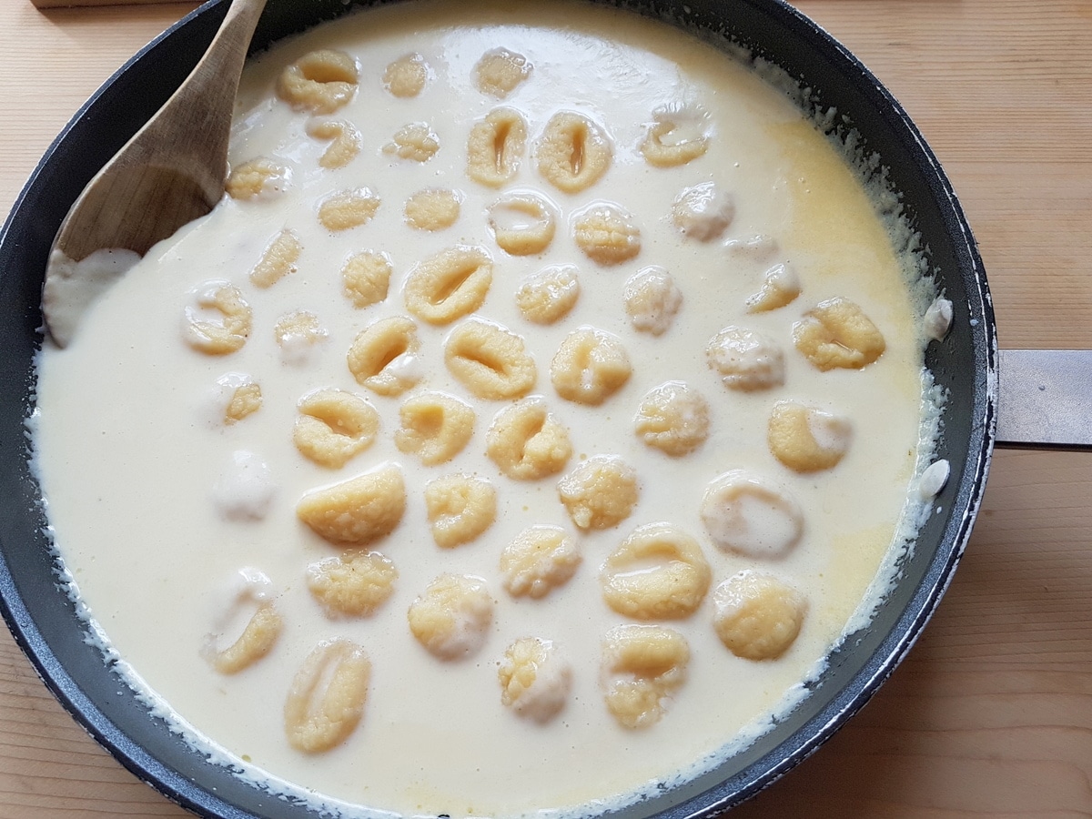 Gnocchi added to the cheese sauce.