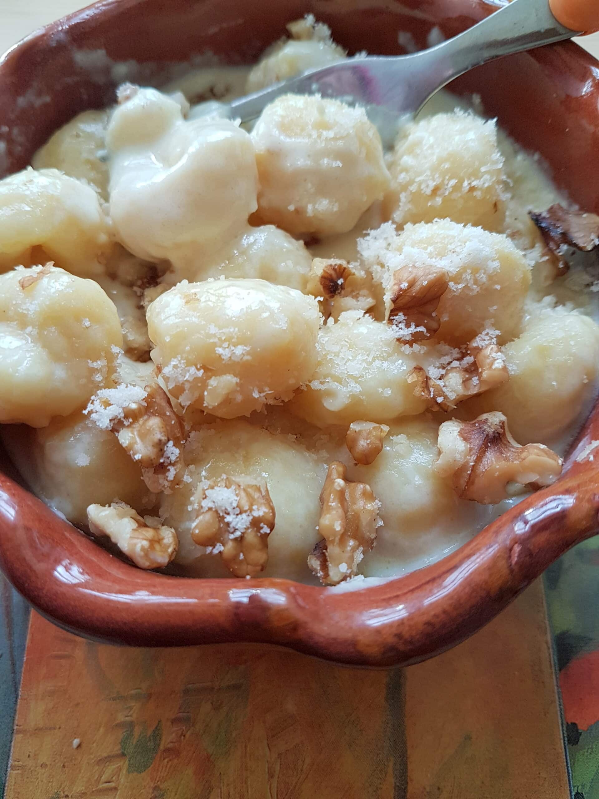 Gnocchi alla Bava with walnuts and cheese in a bowl