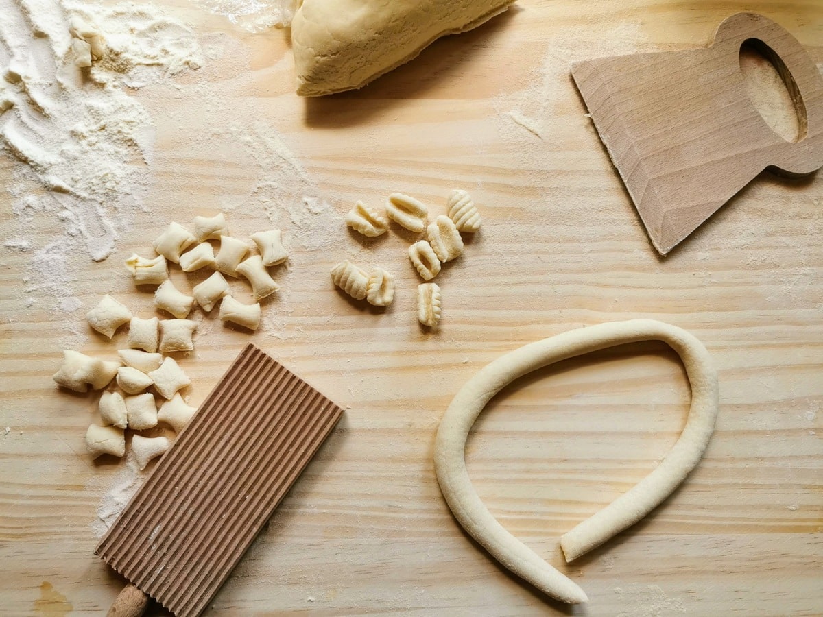 Pasta rolled into a 'snake' with cut pieces of dough and ready Sardinian gnocchi.