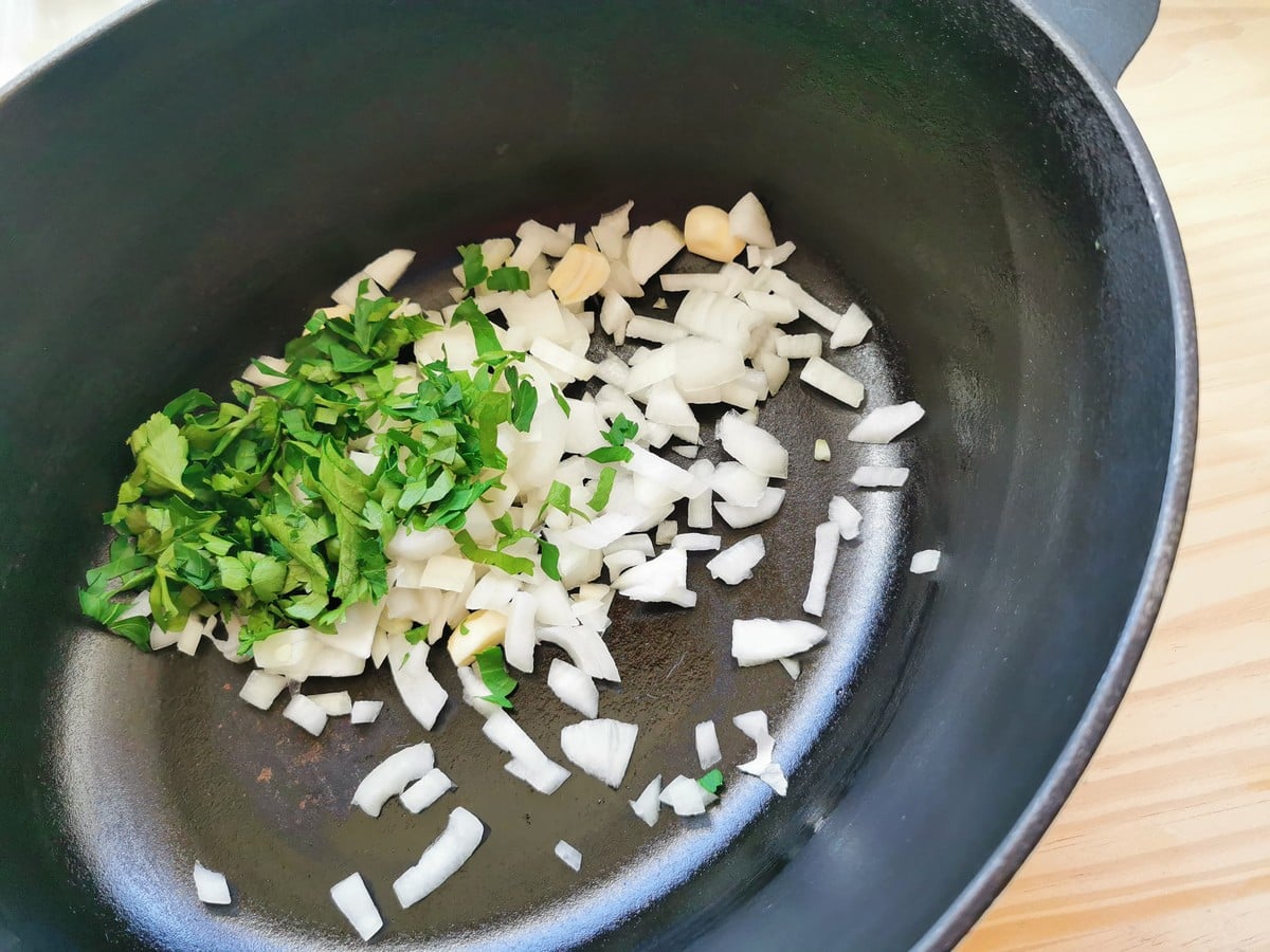 Chopped onion, garlic and fresh parsley in Dutch oven.