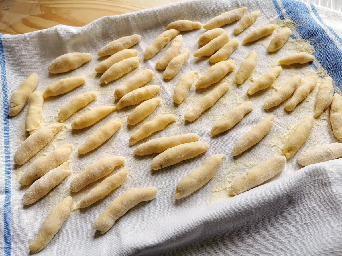 Ready shaped gnocchi della Val Varaita on a flour dusted tea towel.