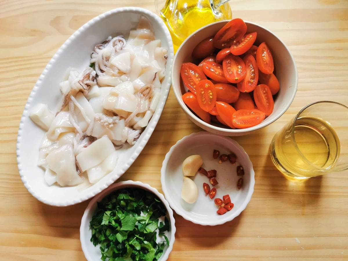 La Calamarata recipe ingredients portioned on a wooden table.