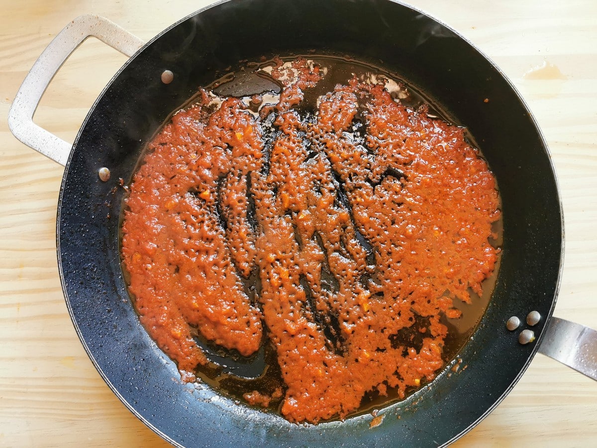 Tomato passata cooking in cast iron skillet.