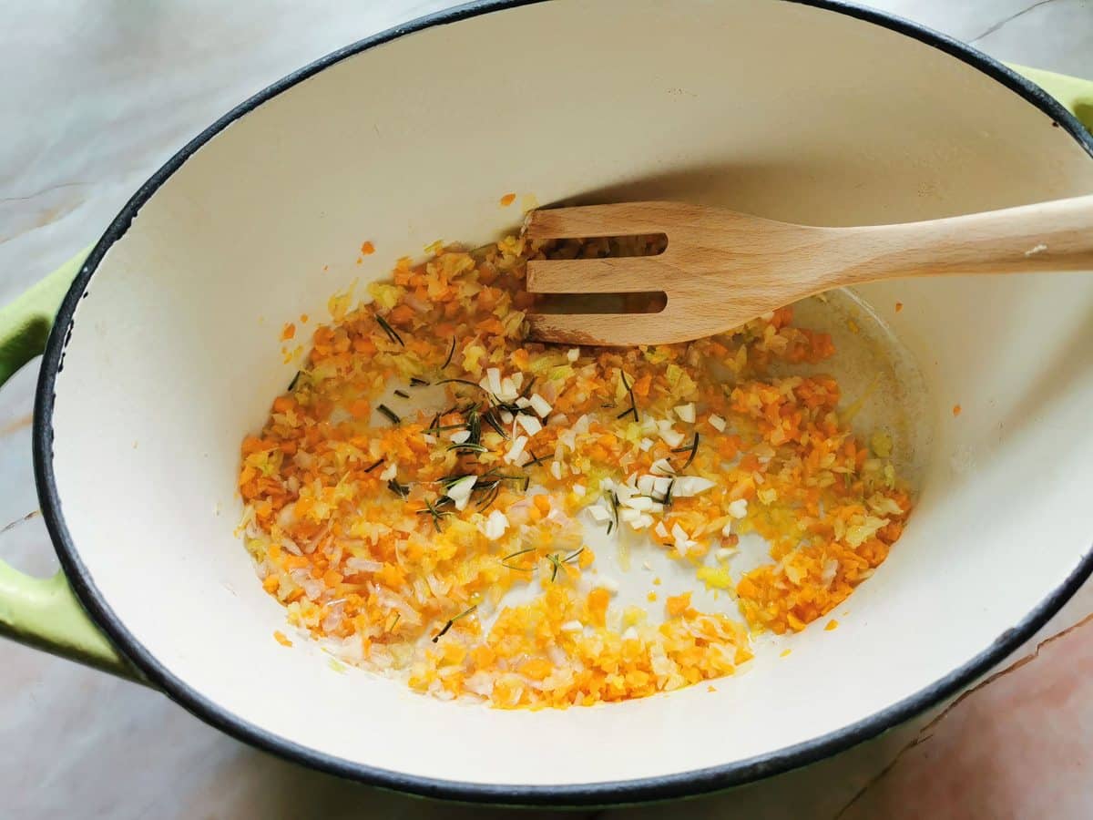 Chopped garlic and rosemary in Dutch oven with the soffritto.