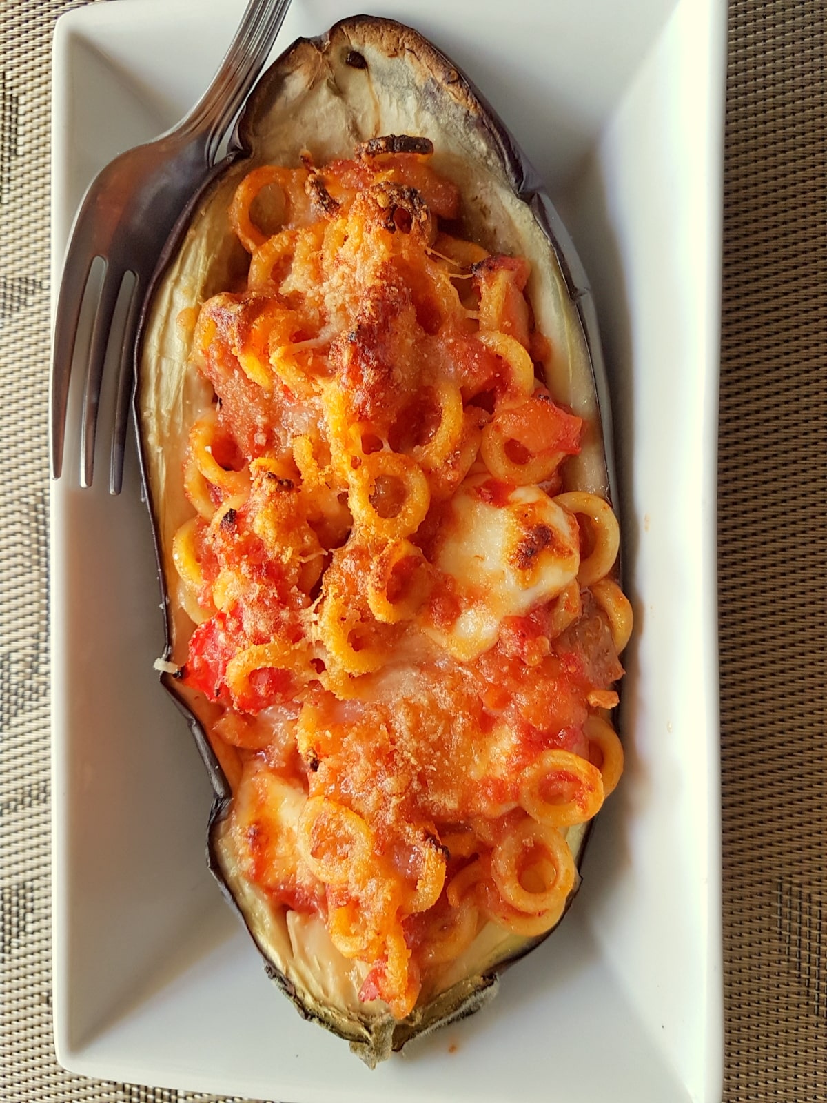 Eggplant boat in a dish with a fork.