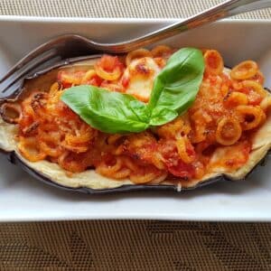 Eggplant boat garnished with basil in a dish.