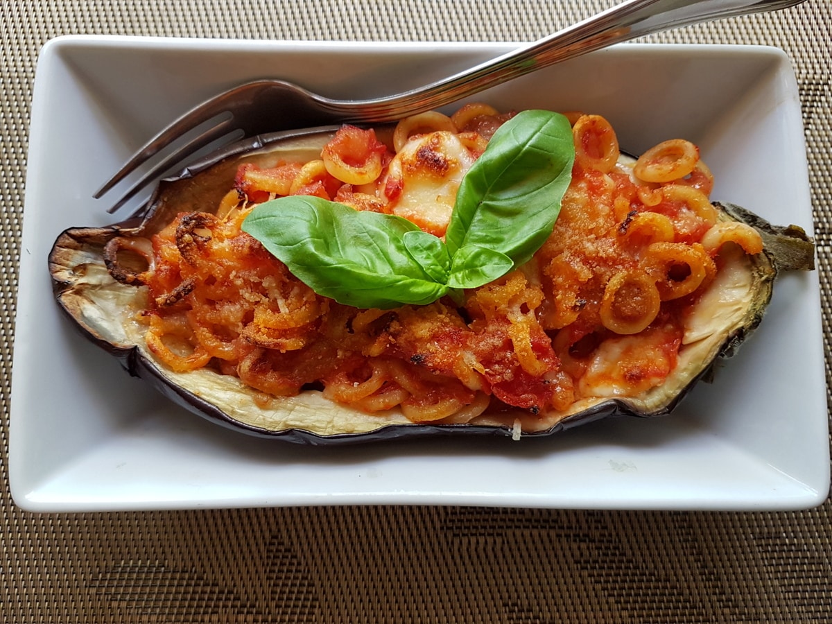 Eggplant boat garnished with basil in a dish.