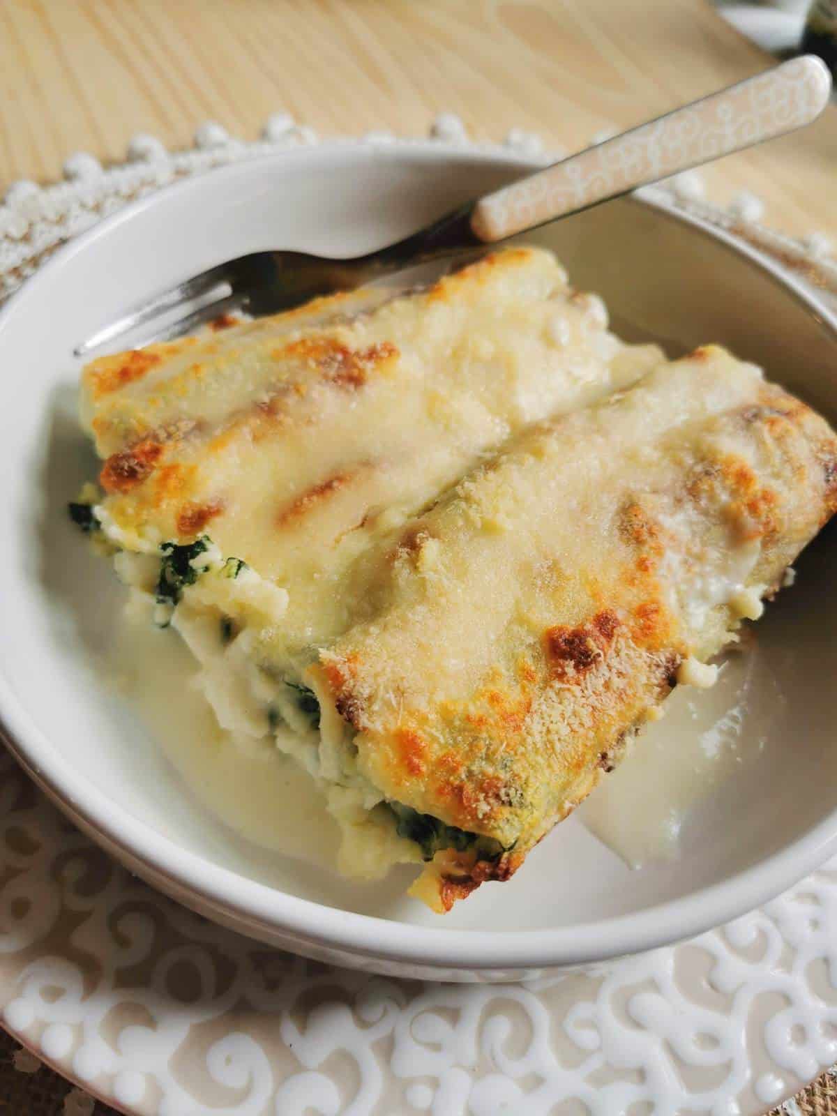Cannelloni with spinach and ricotta with a fork.