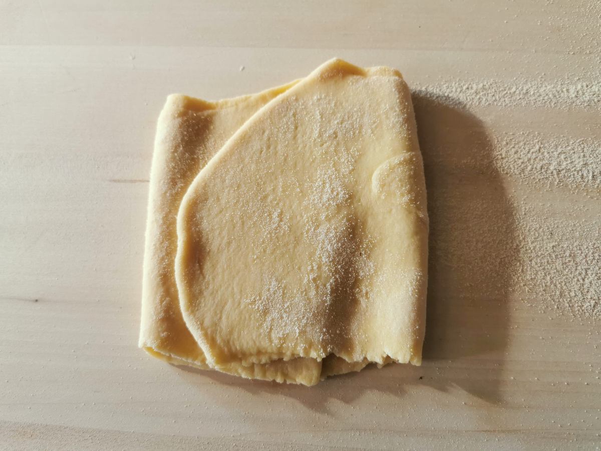 Sheet of tagliatelle pasta dough folded into thirds.