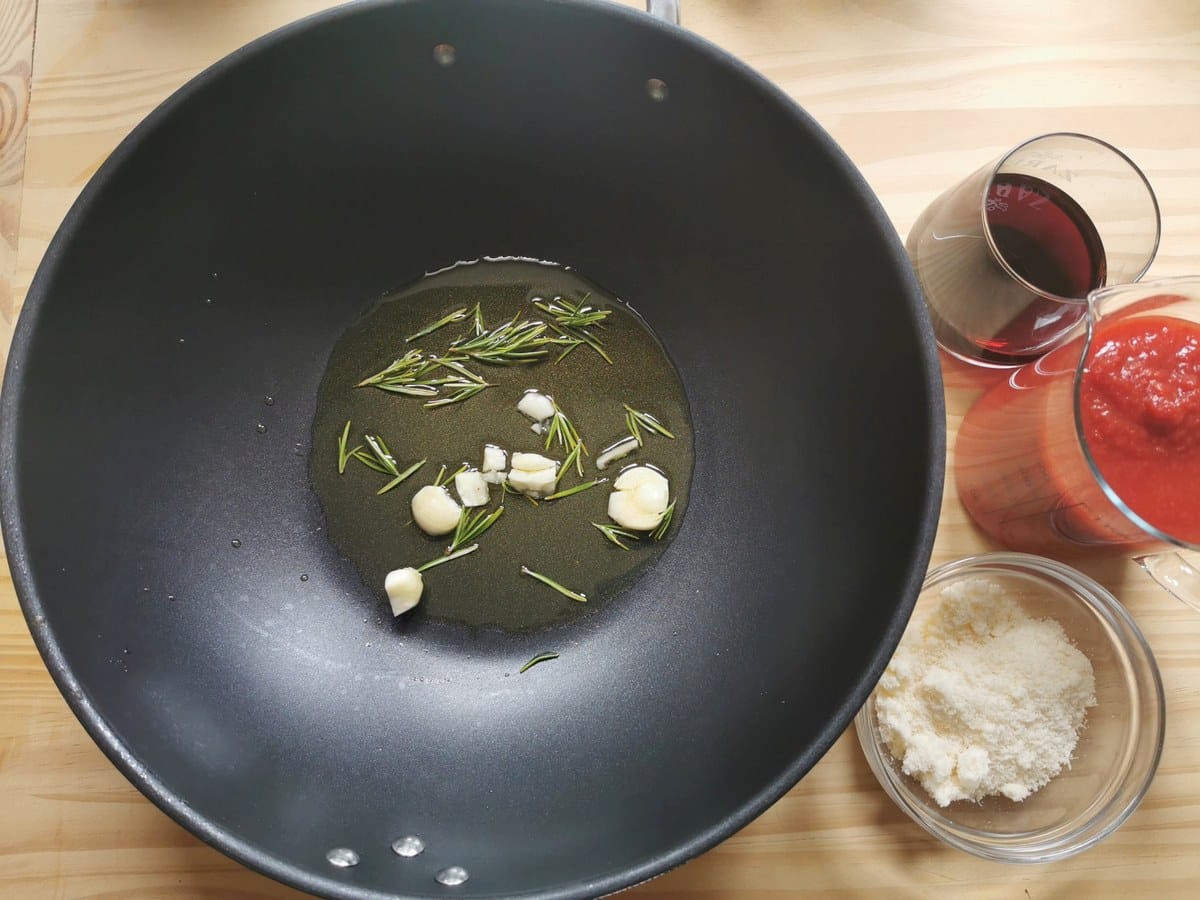 Olive oil, rosemary and garlic in a pan.