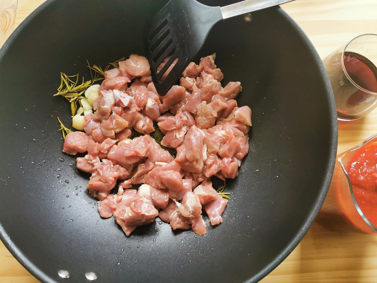 Lamb added to the pan with garlic and rosemary.