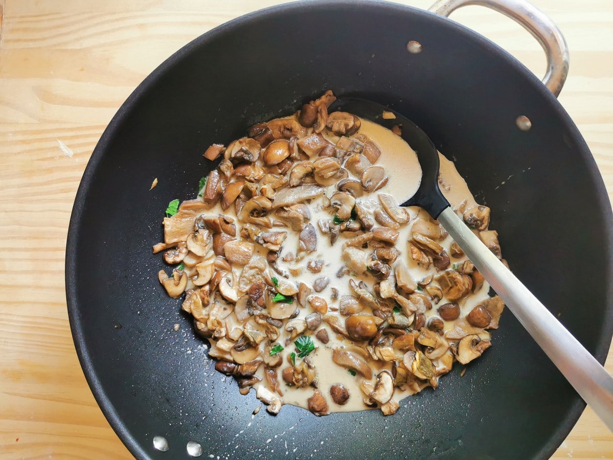 Cream added to the procini and cremini mushrooms in deep skillet.