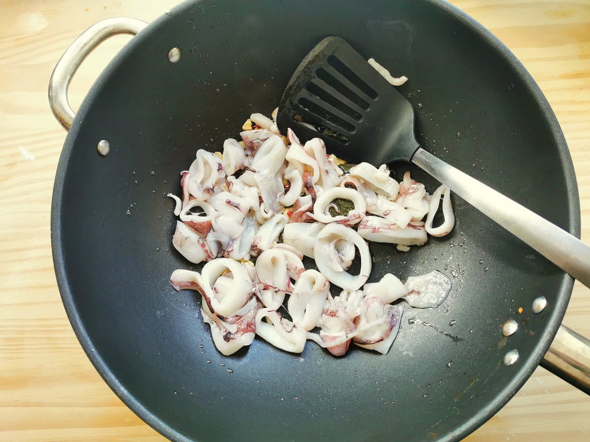 Calamari (squid) cooking in a pan with garlic.