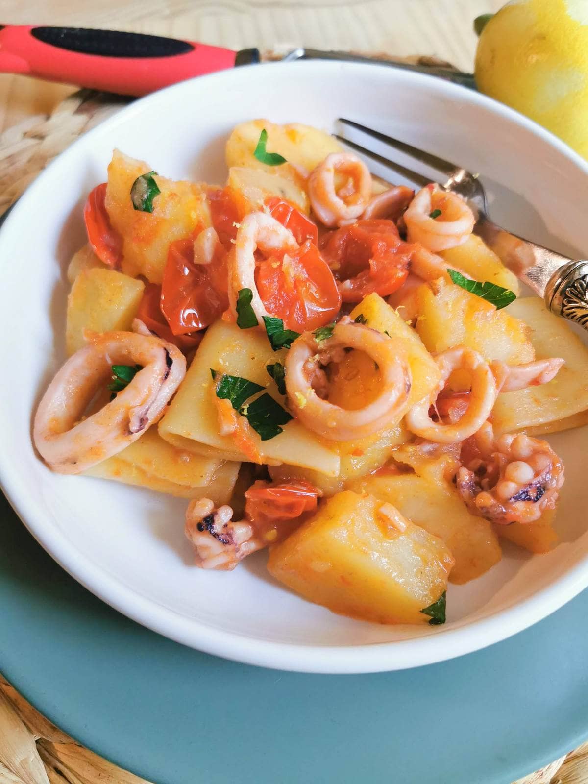 Paccheri pasta with calamari (squid) garnished with flat parsley.