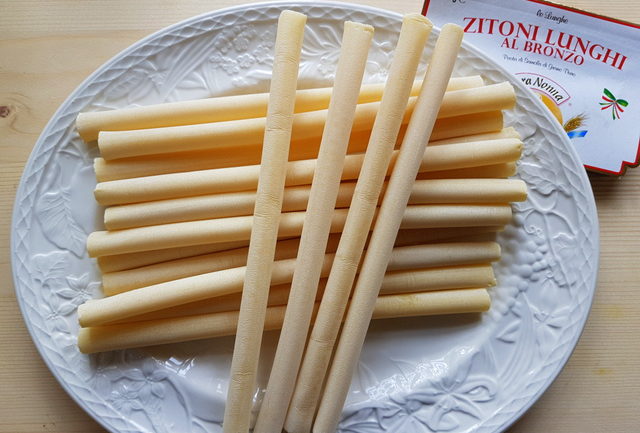 torkad ziti-pasta på vit platta